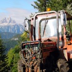Un particolare del trattore con lo sfondo delle Tre Cime di Lavaredo