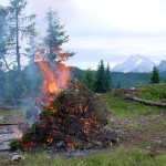 Abbruciamento della ramaglia sul piazzaletto del Tornante "de i Peroi"; sullo sfondo il Col Cervera (dietro la lingua di fuoco) e la massa piramidale dell'Antelao