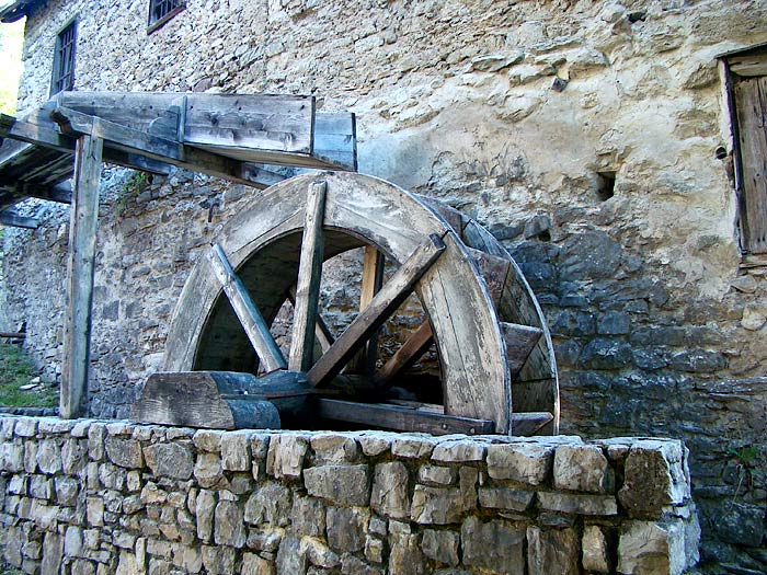 Un primo piano della ruota idraulica: si distinguono i cassetti e la parte finale della roggia, chiamata doccia.