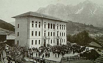 L'edificio scolastico "Giuseppe Da Pra Zotto". Sullo sfondo il Tudaio (m. 2279) e lo Schiavon (m. 2337) (Foto G. Gerardini)